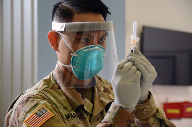 Sgt. Martin Manalo prepares to administer a flu shot at the chapel annex Jan. 15, 2021, on Caserma Ederle. Manalo is a pharmacy technician for the U.S. Army Health Center Vicenza. He and other medics administered approximately 375 doses.