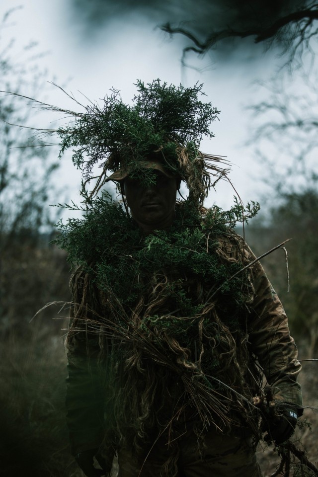 Spc. Jarrod Thomas, a Sniper with 1st Battalion, 12th Cavalry Regiment, 3rd Armored Brigade Combat Team, 1st Cavalry Division, dons his “vegged-up” uniform during a movement, cover, and concealment training exercise, Fort Hood, Texas, Jan. 20,...