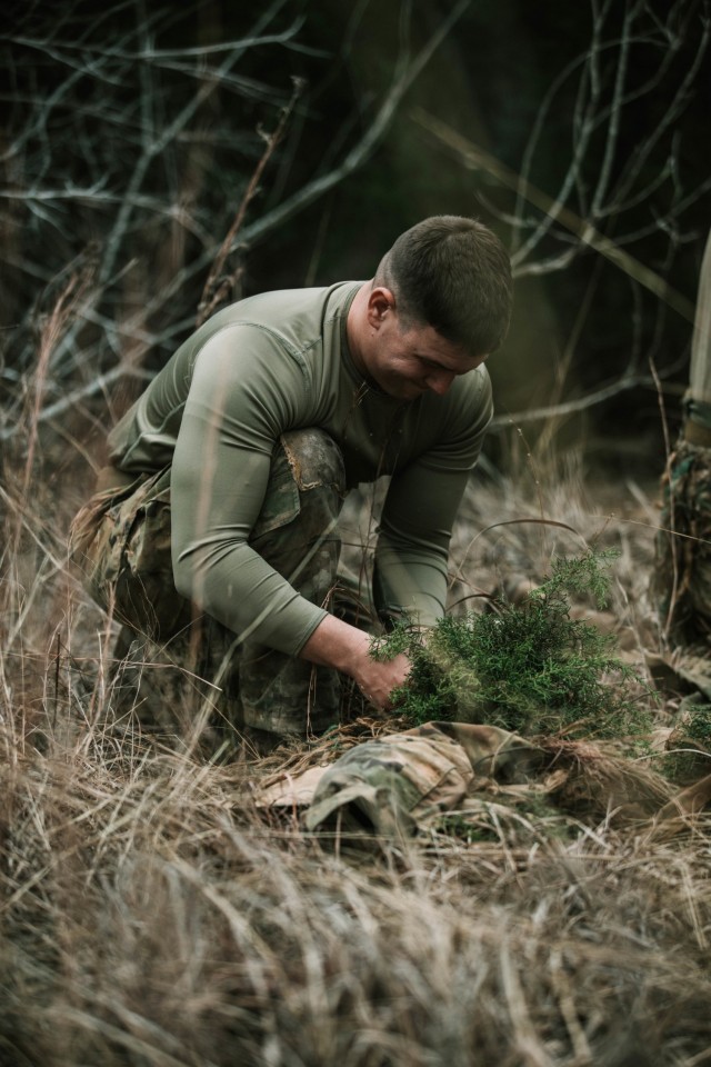 Spc. Jarrod Thomas, a Sniper with 1st Battalion, 12th Cavalry Regiment, 3rd Armored Brigade Combat Team, 1st Cavalry Division, applies “veg.” to his uniform during a movement, cover, and concealment training exercise, Fort Hood, Texas, Jan. 20, 2021. (U.S. Army photo by Sgt. Calab Franklin)