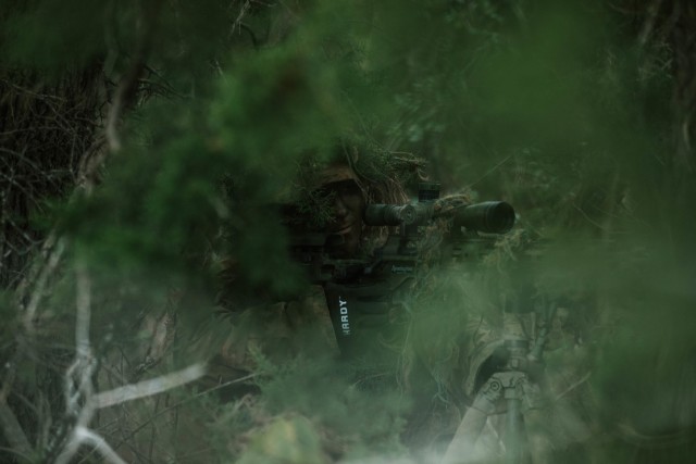 Spc. Jarrod Thomas, a Sniper with 1st Battalion, 12th Cavalry Regiment, 3rd Armored Brigade Combat Team, 1st Cavalry Division, scopes in on an enemy during a movement, cover, and concealment training exercise, Fort Hood, Texas, Jan. 20, 2021....