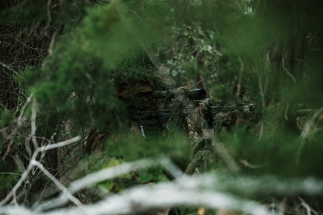 Spc. Jarrod Thomas, a Sniper with 1st Battalion, 12th Cavalry Regiment, 3rd Armored Brigade Combat Team, 1st Cavalry Division, scopes in on an enemy during a movement, cover, and concealment training exercise, Fort Hood, Texas, Jan. 20, 2021....