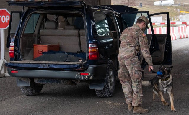 U.S. Army Spc. Ivan Slawsky, a military working dog handler deployed to Regional Command-East, Kosovo Force 28, uses a military working dog to sniff out an improvised explosive device during a joint force protection exercise at Camp Bondsteel,...