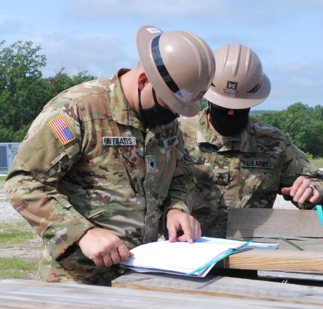 Spc. Dylan Stratis and Sgt. Robert Keys, U.S. Army Prime Power School students, review an electrical schematic design and discuss ways to troubleshoot a power outage scenario during the Prime Power Capstone Training Exercise at the Contingency...