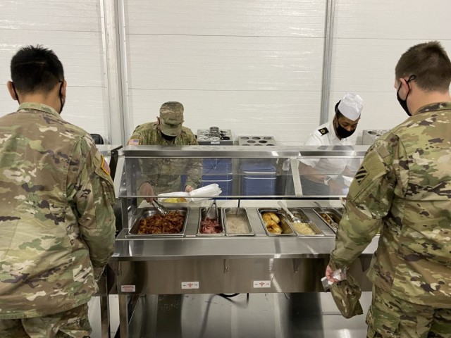Sgt. 1st Class Alechia Riley (right), dining facility manager with 3rd Infantry Division serves Soldiers breakfast during the grand opening of the temporary dining facility Jan. 21. This temporary facility will be open while the permanent facility...