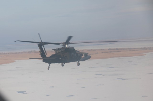 MIHAIL KOGALNICEANU, Romania – A UH-60 from Bravo Co., 5th Battalion, 101st Aviation Regiment flies over a frozen lake near the Black Sea while returning to base from an air assault training with Romanian allies Jan. 20.Working together during...