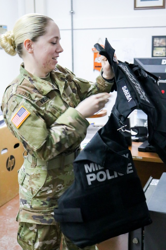 2nd Lt. Allison Vierps, the military police officer in charge of Regional Command-East, Kosovo Force 28, puts on her protective vest while responding to a call during a joint force protection exercise at Camp Bondsteel, Kosovo, on Jan. 23, 2021. A...