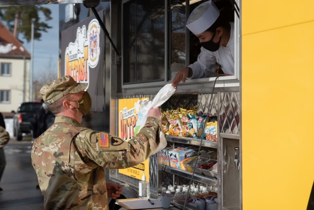 1st Sergeant Andrew Gregory the first sergeant for 51st Composite Truck Company picks up his order at  U.S. Army Garrison Bavaria's newest addition in food-service; the Culinary Outpost food truck, Jan 8.