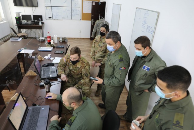 MIHAIL KOGALNICEANU, Romania – CW1 Kayla Alley and CW2 Grant Imhoff, UH-60 Pilots, Bravo Co., 5th Battalion, 101st Aviation Regiment, meet with Romanian counterparts from 572nd Puma Squadron here Jan. 15 to plan a joint air assault training...