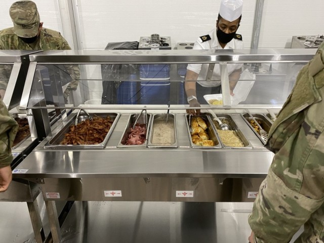 Sgt. 1st Class Alechia Riley (right), dining facility manager with 3rd Infantry Division serves Soldiers breakfast during the grand opening of the temporary dining facility Jan. 21. This temporary facility will be open while the permanent facility...