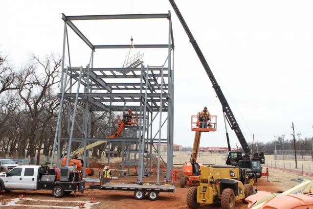 Spencer Soto, a crane operator with Belger Crane Service in Wichita Falls, Texas, hoists a 3,500-pound segment of an internal stairway into the frame of the new Treadwell Tower at Fort Sill, Oklahoma. PWE, Incorporated of Lawton, lead contractor...