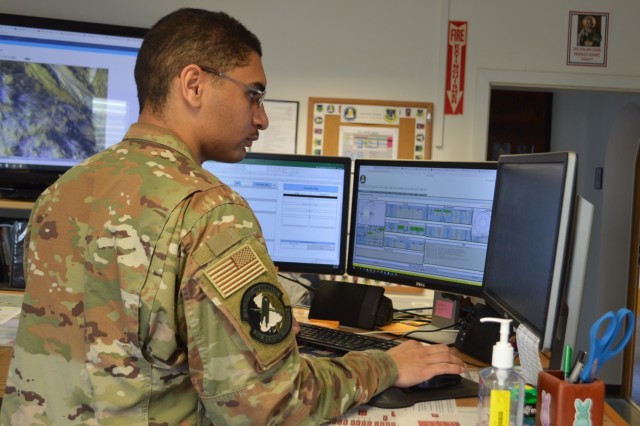 Senior Airman Christopher Ware, forecaster, Detachment 4, 7th Combat Weather Squadron, checks the weather on his computer at Katterbach Airfield Base Operations, Germany. Ware and eight other Airmen are attached to the 12th Combat Aviation Brigade providing decision-grade weather intelligence and combat-credible forces.
