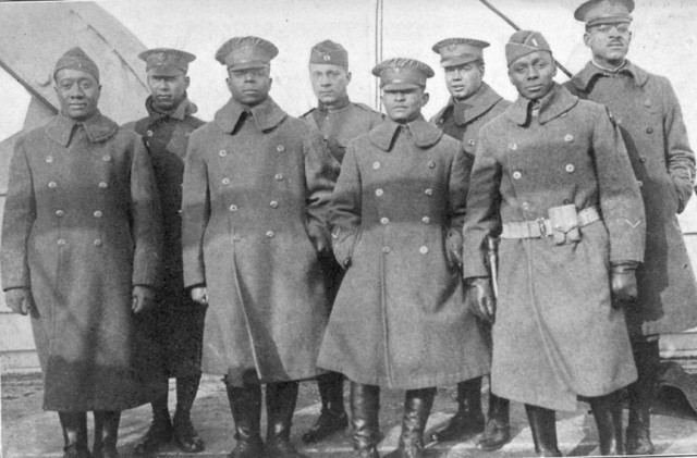 Officers of the 370th (Old 8th Illinois) on the deck of the La France IV before landing in New York City. Reading L to R: 2nd Lt. Lawson Price; 2nd Lt. L. W. Stearls; 2nd Lt. Ed. White; 2nd Lt. Eli F. E. Williams; 1st Lt. Oasola Browning; Capt. Louis B. Johnson; 1st Lt. Frank Bates; 1st Lt. Binga Desmond.
