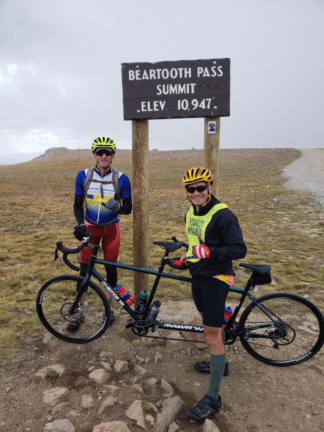 Staff Sgt. Mike Murphy (right) and Marc Cattapan (left) pose in front of the Beartooth Pass sign, the highest point in the Beartooth Challenge ride. (Photo via Marc Cattapan)