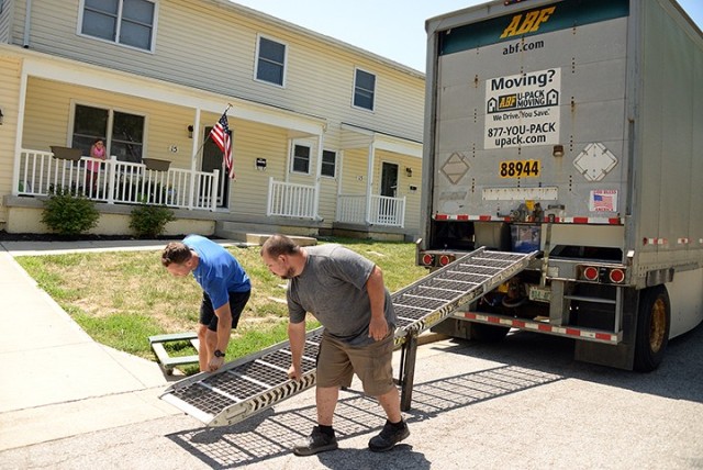 Eleven-year-old Cami Hunter watches from the porch as her father, Maj. Ben Hunter, incoming Command and General Staff Officer Course student, and ABF driver Ray Lilotta move a ramp into place for unloading their household goods July 10, 2020, on post. The Hunter family opted for a do-it-yourself move from Apex, N.C., to Fort Leavenworth, packing their own household goods and hiring a driver to transport their belongings from post to post. Photo by Prudence Siebert/Fort Leavenworth Lamp