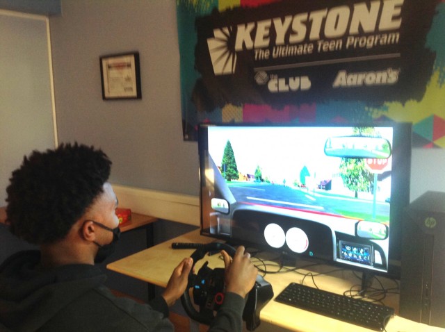 A student with Baumholder Child and Youth Services uses the "old" simulator to test his driving skills as part of the Boys and Girls Clubs of America UPS Road Code driver education program.
