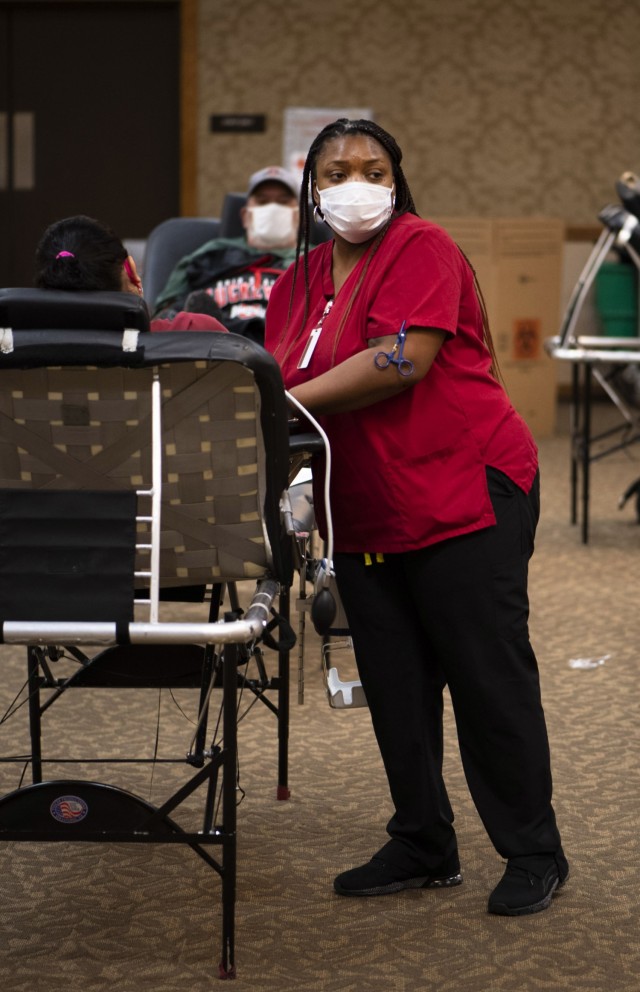 Williette Simmons, a volunteer with American Red Cross  assists a donor in giving blood during a Community Blood Drive at the NCO Club  on post Jan. 25.