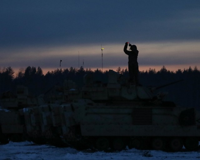 A 2nd Battalion, 8th Cavalry Regiment Trooper attaches glow sticks to the antenna of his Bradley Fighting Vehicle before starting an iteration of a nighttime gunnery Jan. 22, 2021, at the Pabrade Training Area, Lithuania. The Bradley Fighting...