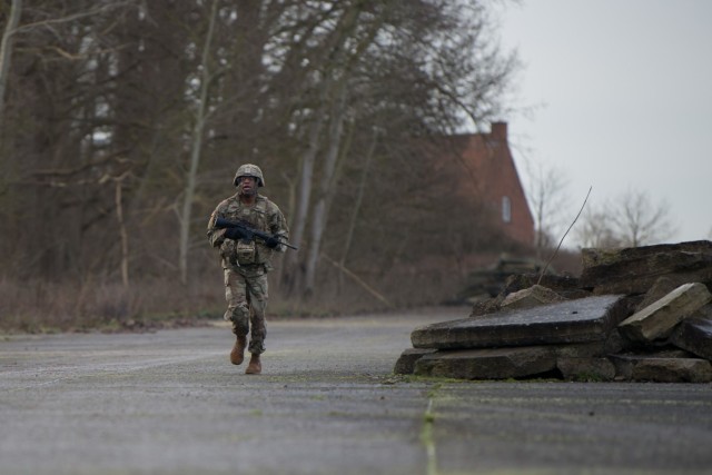 U.S. Army Pfc. Arnando Smith, a U.S. Army Garrison Benelux MP assigned in Chièvres, Belgium, runs in the training area as he competes in the medical lane of the Best Warrior Competition, on Chièvres Air Base, Belgium, Jan. 26, 2021. (U.S. Army...