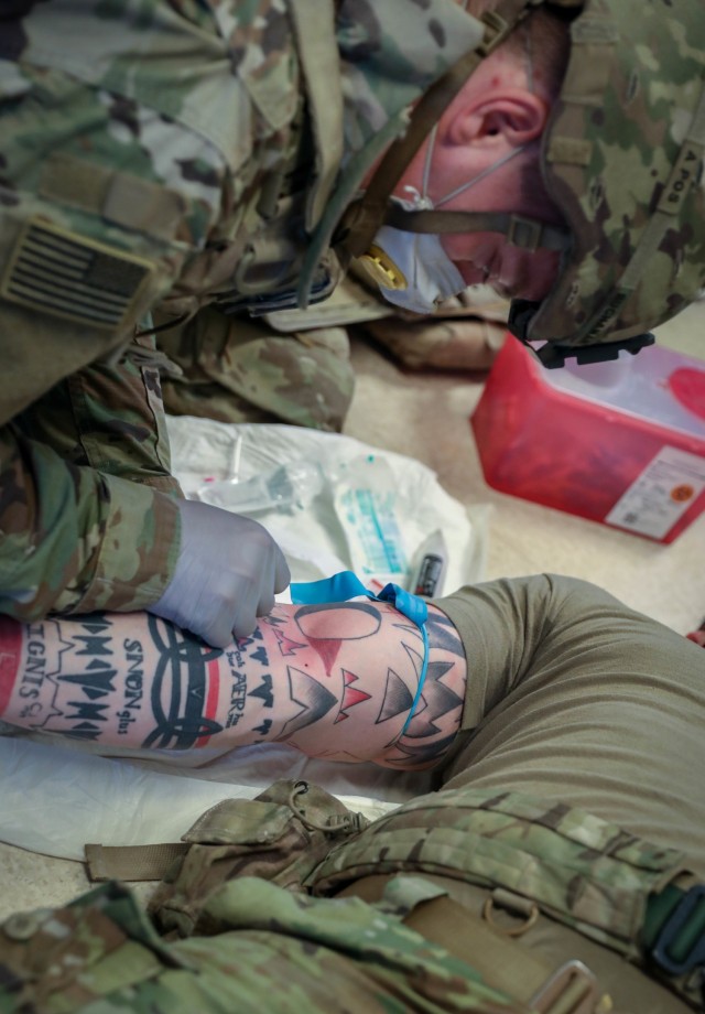 Pfc. Lucas Buchanan, a combat medic assigned to Headquarters, Headquarters Company, 2nd Battalion, 8th Cavalry Regiment, starts an IV on a simulated battlefield casualty during Tactical Combat Casualty Care Jan. 30, 2021, at the Pabrade Training...