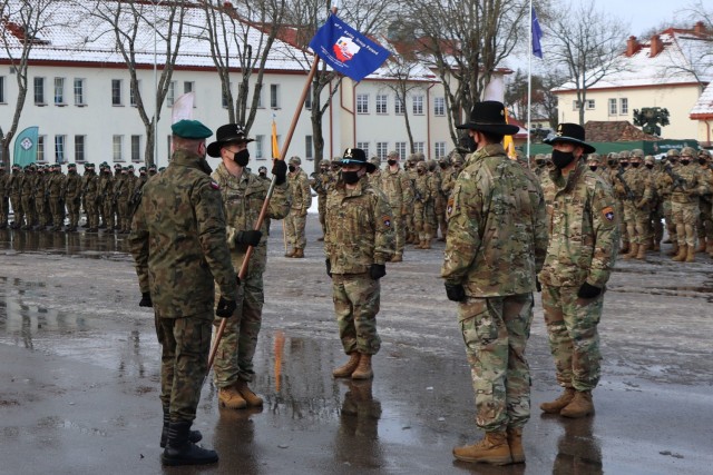 United States Army Lt. Colonel Jason Adler, 1st Squadron, 2d Cavalry Regiment, holds the flag he received from Jeffery Higgins, 2d Squadron, 2d Cavalry Regiment signifying that Adler is the new NATO enhanced Forward Presence Battle Group Poland Commander. (Photo courtesy of eFP BGP PAO)