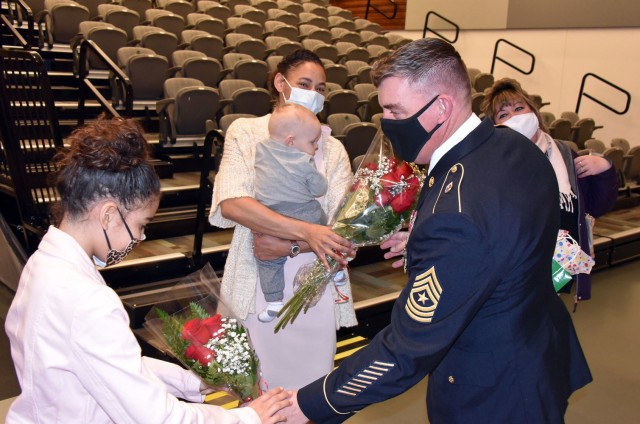 Sgt. Maj. Corey A. Lord presents flowers to his wife, Christiana, and daughter, Elena, following his retirement ceremony on Jan. 29 at Fort Detrick, Maryland. Lord, a native of Maine, retired after 30 years of service to the U.S. Army.