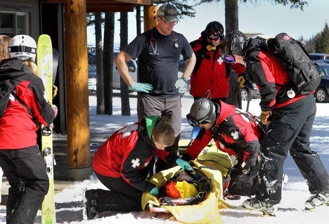 Tessa Morris leans over to help a skier severely injured while Morris was on ski patrol duty. Morris began patrolling as a volunteer when she was in high school.