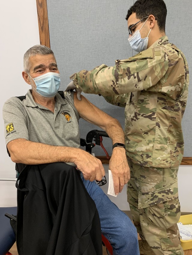 Pvt. Juan Rojas, with 2nd Armored Brigade Combat Team, 3rd Infantry Division provides a COVID-19 vaccination to U.S. Reserve Ambassador Louis Carreras, Jan. 22 at Winn Army Community Hospital on Fort Stewart.