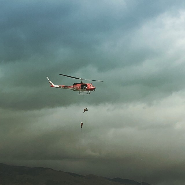 Firefighting helicopter rapellers train during story weather. Tessa Morris participated in the training so that she could rappel behind fire lines during her off months as a ski patrol director.