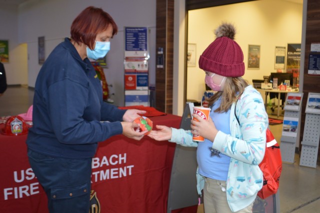 A U.S. Army Garrison Ansbach fire prevention instructor gives out a face covering to an Ansbach community member Oct. 6, 2020 at the Exchange on Urlas Kaserne.  U.S. Army Garrison Ansbach Directorate of Emergency Services firefighters who were...