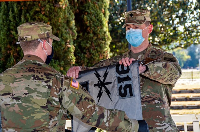 Lt. Col. Matthew Davis, commander of the 915th Cyberspace Warfare Battalion (right), and Capt. James Conway, the newly appointed commander of the battalion’s Bravo Company, unfurl the company’s guidon at the ceremony activating the unit, at Fort Gordon, Ga., Jan. 29, 2021. The ceremony was modified for the current operational environment during the COVID-19 pandemic, while continuing to honor military traditions. (Photo by Staff Sgt. John Portela)
