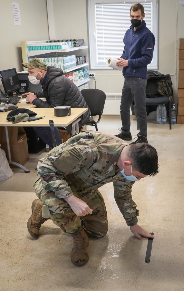 Capt. Jacob Andvik, the battalion logistics officer for 2nd Battalion, 8th Cavalry Regiment, places an arrow made of tape on the floor of the Pabrade Training Area, Lithuania Mobile Field Exchange Feb. 1, 2021. The arrow is one of the final touches made to the MFE before their opening day. After several months of planning by Andvik and Exchange management, the MFE is the first to be established within the Baltic States. (Photo by U.S. Army Sgt. Alexandra Shea)