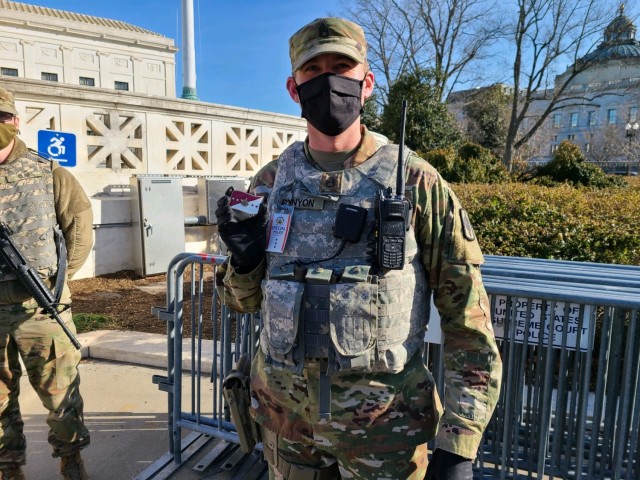 Staff Sgt. Kyle Runyon of Topeka, noncommissioned officer in charge of Task Force Kansas, the contingent of Kansas Guardsmen sent to the U.S. Capital region, displays a coin presented to him by 
...