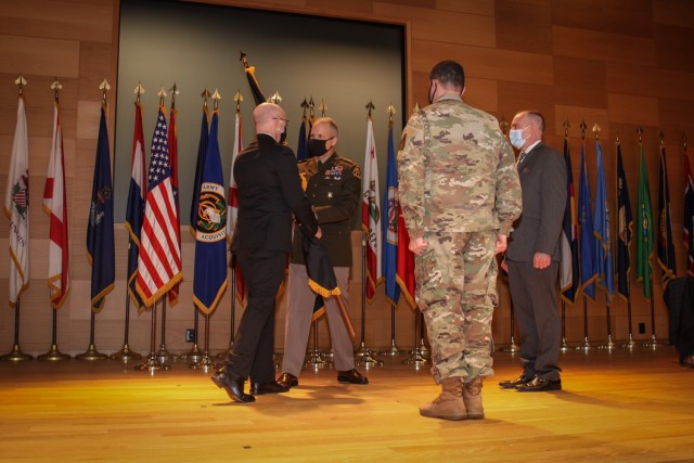 Ward Roberts passes the colors for Project Manager Interoperability, Integration and Services to the PEO C3T, Brig. Gen. Robert M. Collins. Incoming Project Manager, Matthew Maier, received the colors from Brig. Gen. Collins during a ceremony held...