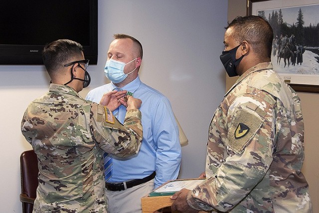 Garrison Professional of the Year Josh Altice, workforce development specialist, Garrison Human Resources Department, is presented the Army Civilian Service Commendation Medal by Garrison Commander Col. Harry Hung and Garrison Command Sgt. Maj....