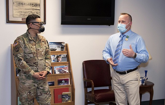 Garrison Commander Col. Harry Hung listens to remarks from Garrison Professional of the Year Josh Altice, workforce development specialist, Garrison Human Resources Department, after presenting him with the Army Civilian Service Commendation Medal...