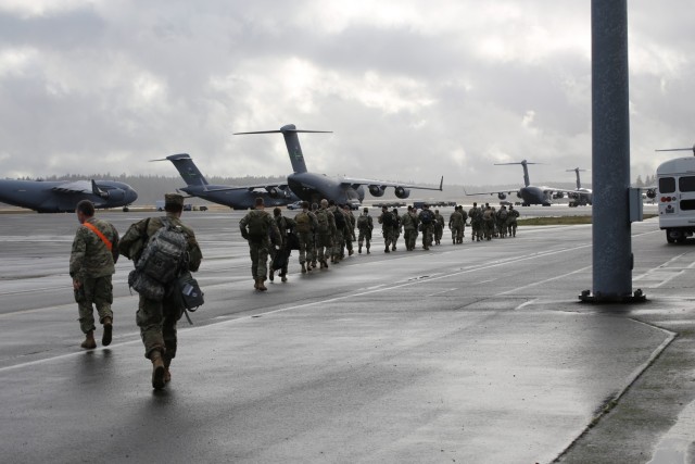 Washington National Guard members leave the McChord Field passenger terminal and walk to an awaiting KC-135 to head to D.C. to support Operation Capitol Response Jan. 15, 2021, at Joint Base Lewis-McChord, Wash. The 141st Air Refueling Wing flew...