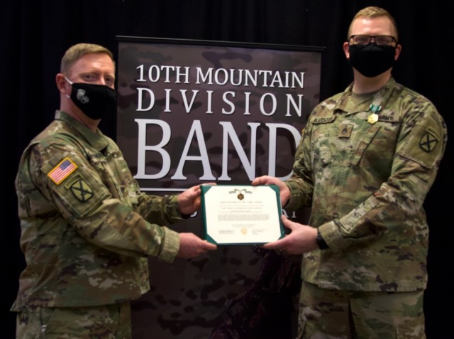 Staff Sgt. William Karsten, a tuba player and operations noncommissioned officer with the 10th Mountain Division Band, (right) is presented with the Army Commendation Medal by Lt. Col. Paul Shepard, a plans officer with the Directorate of Plans, Training, Mobilization and Security during a ceremony on Feb. 3 at Fort Drum. He was awarded for his quick actions during a garage fire on Shepard&#39;s property in November. (10th Mountain Division Band photo)