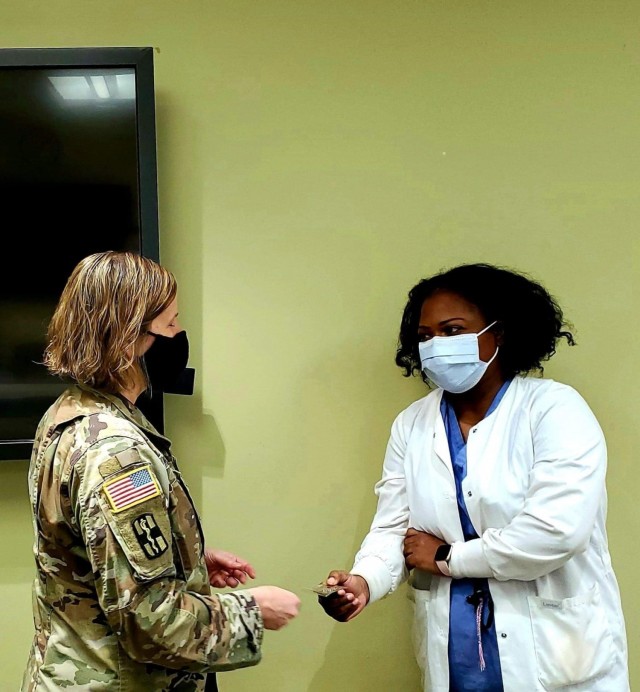 Fort Benning Martin Army Community Hospital Commander Col. Melissa Hoffman presents a coin to Women's Health Clinic staff midwife Capt. Iris Evans for going above and beyond in her support of patients.