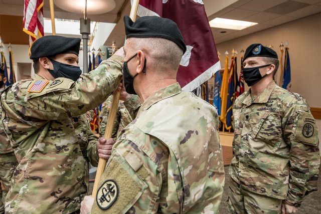 Col. Scott Roofe, acting commander of Madigan Army Medical Center, transfers its Soldier Recovery Unit’s colors to incoming commander Lt. Col. Woodrow Pengelly at a change of command ceremony held on Feb. 3, at Madigan on Joint Base Lewis-McChord, Wash.