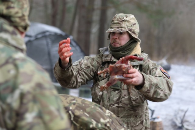 British Troops from enhanced Forward Presence Battle Group-Poland practice preparing fresh game for a meal during a cold weather operators'  course Dec. 11, 2020 at Bemowo Piskie Training Area, Poland. (U.S. Army photo by Staff Sgt. Elizabeth O....