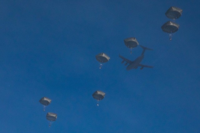Paratroopers with 3rd Battalion, 509th parachute infantry regiment, 4th Infantry Brigade Combat Team (Airborne), 25th Infantry Division, descend from the sky during an airfield-seizure operation at Donnelley Training Area, Alaska, Feb., 7, 2021. Paratroopers will spend approximately ten days in the Alaskan cold conducting a near-peer combat scenario beginning with an airborne operation to secure an airfield. (U.S. Army photograph by Staff Sgt. Alex Skripnichuk)