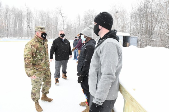 Col. Jeffery Lucas, Fort Drum garrison commander, joins Eric Wagenaar, deputy to the garrison commander, and Command Sgt. Maj. Roberto Munoz, garrison senior enlisted adviser, in presenting challenge coins to the ice rink operations staff. So far, 2021 has seen the type of North Country winter weather that is making the ice rink a hot spot for outdoor recreation. Since the rink opened on Jan. 25, it has seen more activity in the first 10 days than all of last season.   (Photo by Mike Strasser, Fort Drum Garrison Public Affairs)