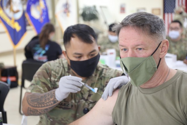 Spc. Vincebryan Marquez, healthcare specialist, 228th Combat Support Hospital, administers the Moderna COVID-19 vaccine to Lt. Col. Scott Gadberry, anesthesiologist, 228th Combat Support Hospital, at Camp Arifjan, Kuwait, Jan. 18, 2021. Camp...