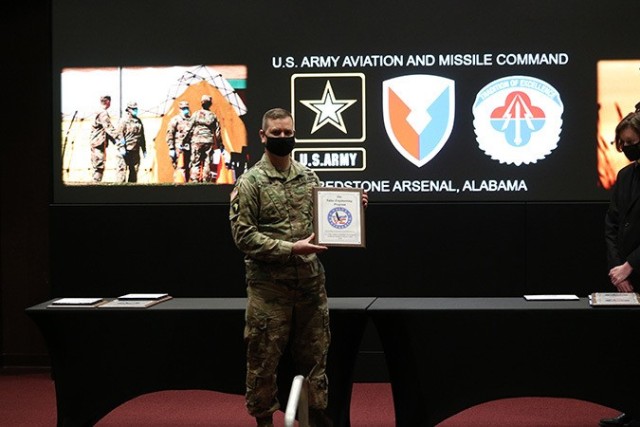 U.S. Army Aviation and Missile Command Commanding General Maj. Gen. Todd Royar displays one of the plaques presented to awardees during the Value Engineering/ Army Working Capital Fund Investment Program Awards Ceremony Feb. 8 at Bob Jones...
