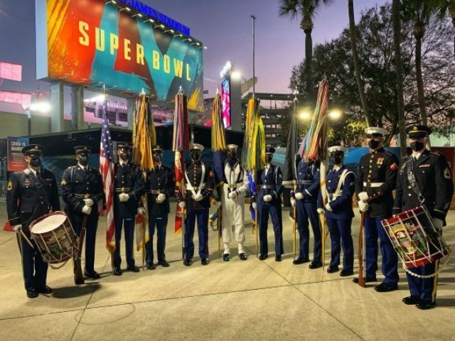 The U.S. Armed Forces color guard stands at the entrance of the Raymond James Stadium just after their performance at Super Bowl LV in Tampa, Florida, Feb. 7, 2021. From left to right, U.S. Army Sgt. 1st Class Derek Stults, U.S. Army Sgt....