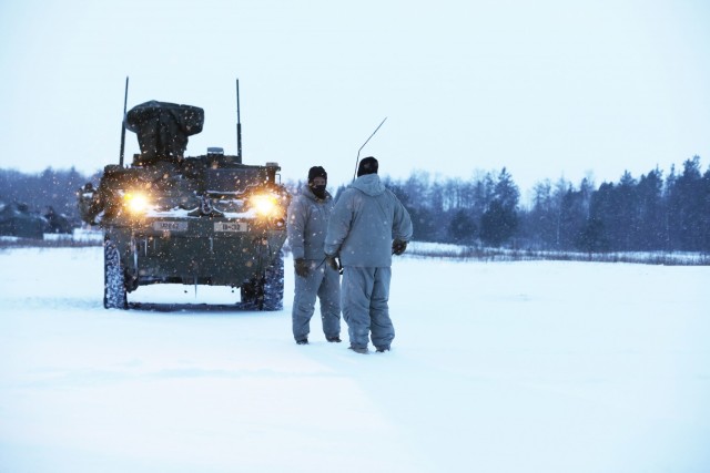 U.S. Army Soldiers from Bull Troop, 1st Squadron, 2d Cavalry Regiment, enhanced Forward Presence Battle Group Poland, stand in front of a stryker before crew level maneuver platform gunnery qualification tables February 09, 2021, on a range at...