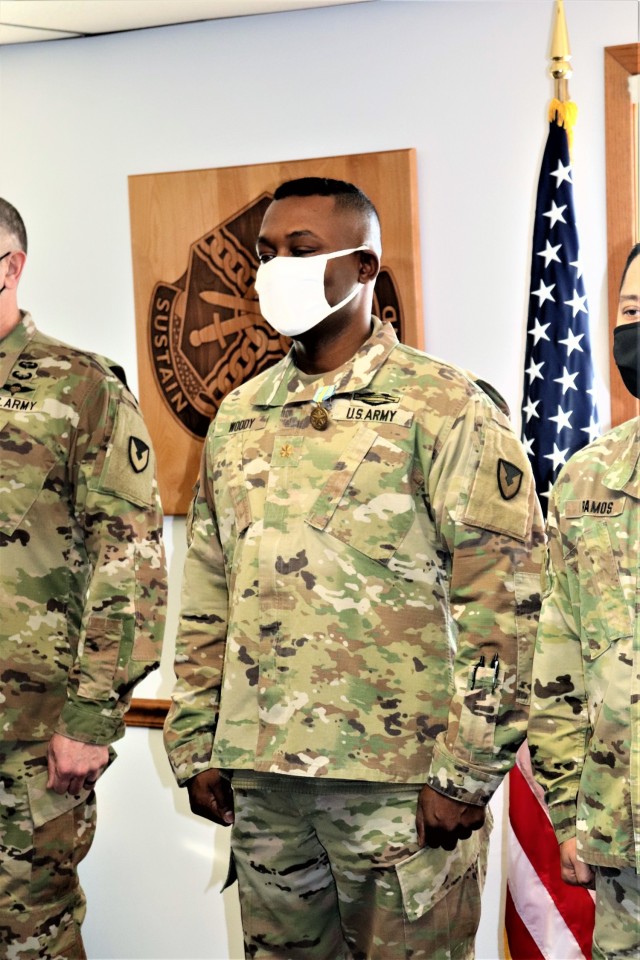 Maj. Eddie Woody, commander of U.S. Army Garrison-Fort McCoy’s Headquarters and Headquarters Company, stands at attention after being presented the Military Outstanding Volunteer Service Medal (MOVSM) by Garrison Commander Col. Michael D. Poss...