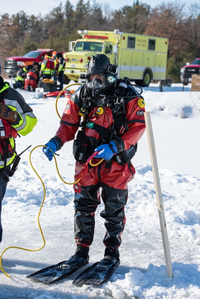 A firefighter with the Directorate of Emergency Services Fire Department dive team prepares for dive training under ice Feb. 3, 2021, at Big Sandy Lake on South Post at Fort McCoy, Wis. The department conducts surface and dive training with ice-covered lakes on post annually. (U.S. Army Photo by Cedar Wolf, Fort McCoy Multimedia-Visual Information Office)
