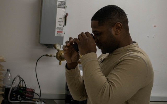 U.S. Army Spc. Dyami Stanley, an armorer with the 317th Support Maintenance Company, 18th Combat Sustainment Support Brigade, 16th Sustainment Brigade, out of Baumholder, Germany, inspects an M68 Close Combat Optics during an annual weapons inspection at Camp Bondsteel, Kosovo, on Feb. 9, 2021. Weapon accessories such as CCOs require annual maintenance inspections. (U.S. Army National Guard photo by Sgt. Jonathan Perdelwitz)