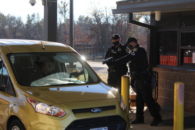 A police officer with the Directorate of Emergency Services Police Department scans an identification card while practicing COVID-19 safety protocols Dec. 3, 2020, at Fort McCoy, Wis. Throughout the installation's pandemic response, which started...